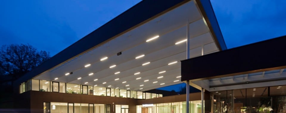 Gemeindezentrum Lannach bei Nacht. Fassade mit Fassadenplatten Farbe kernbraun.